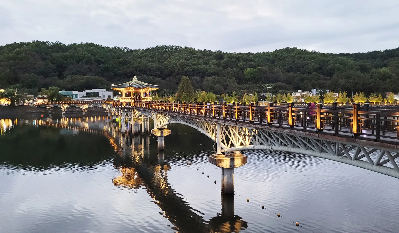 Woryeonggyo Bridge and its pavilion lit at dusk over the river, Andong