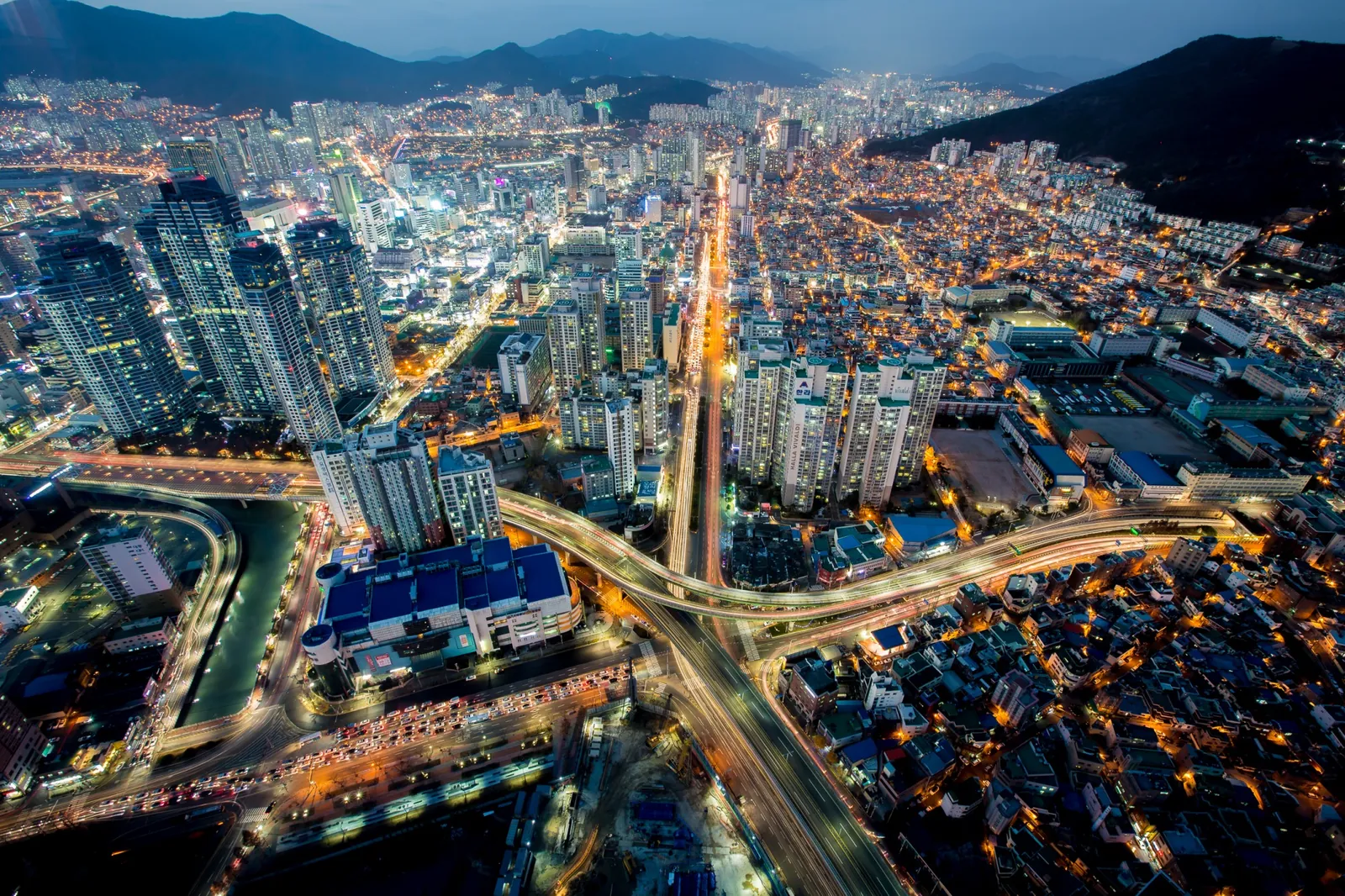 Seomyeon junction at night from above, with lit roads and towers spreading across central Busan