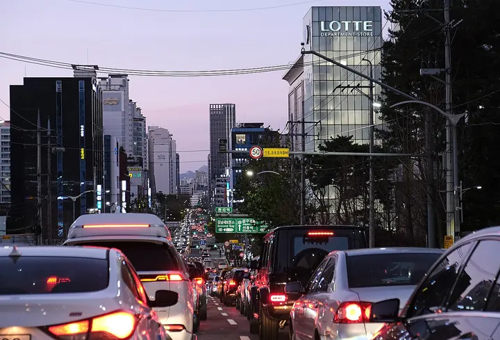 Traffic and buildings along a street in Gangnam, Seoul, at dusk