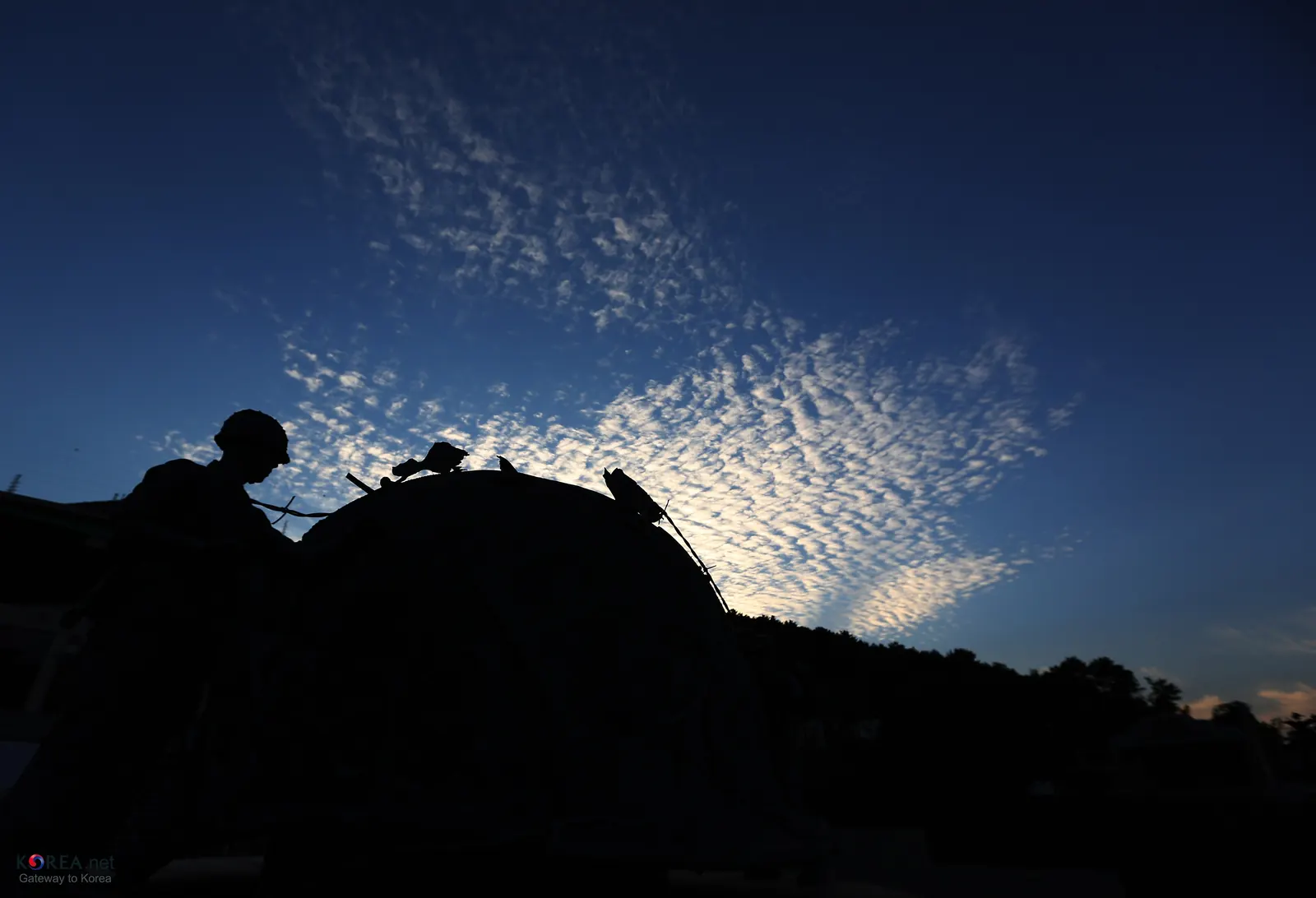 Statues silhouetted against the evening sky at Geoje POW Camp Historic Park, Gohyeon