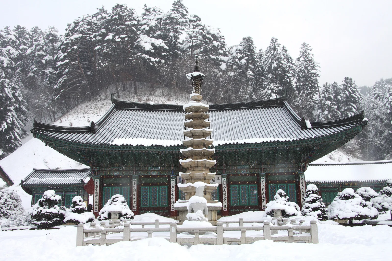 The stone pagoda and main hall of Woljeongsa Temple under snow, Odaesan